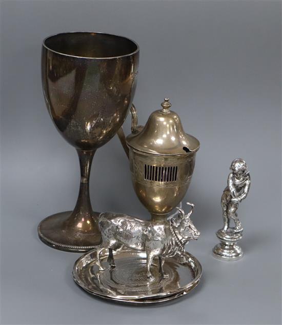 A Victorian silver goblet, a silver mustard pot, two Middle Eastern dishes, a model cow and a model of a cherub.